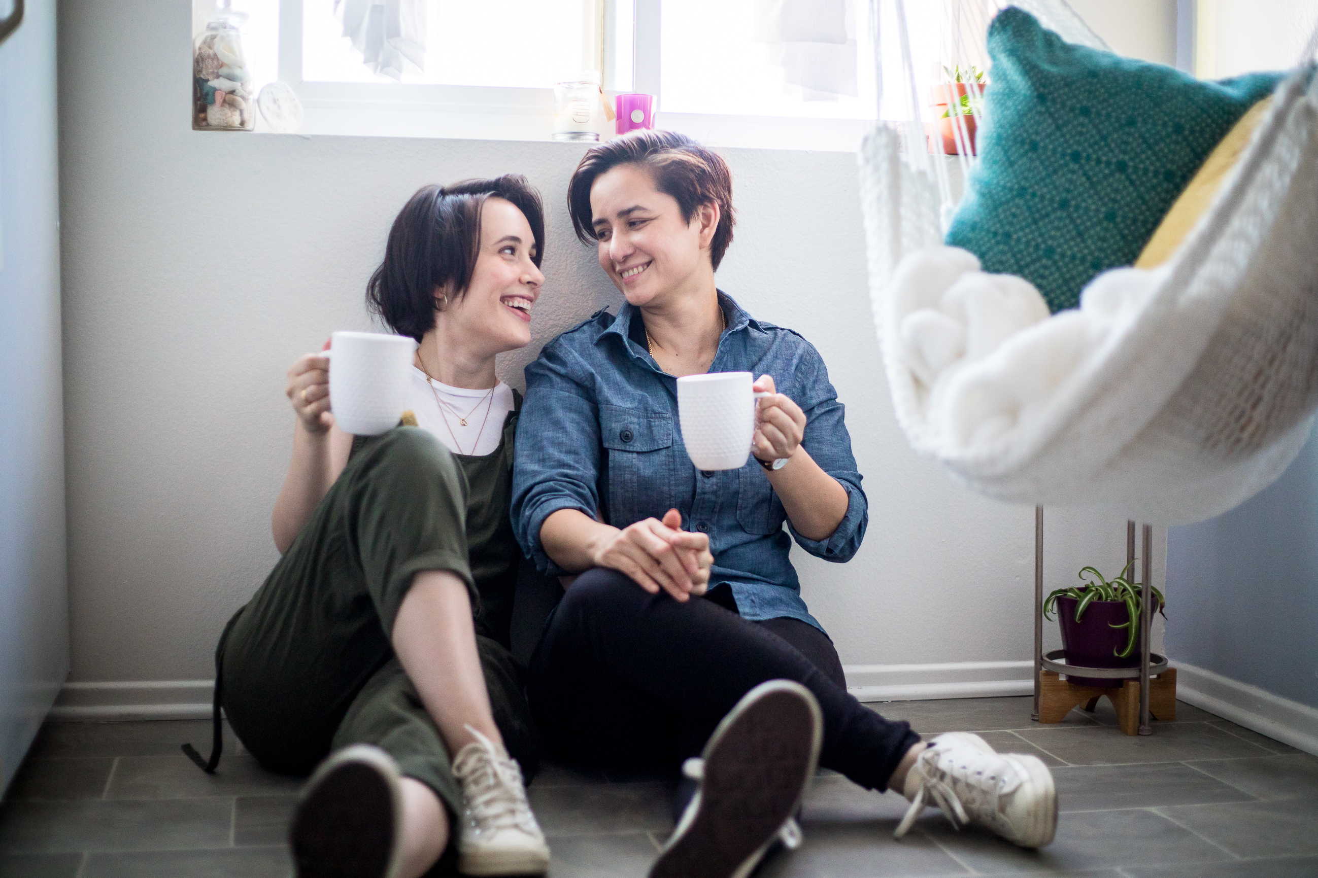 lesbian couple sitting on the floor drinking coffee at home in Los Angeles